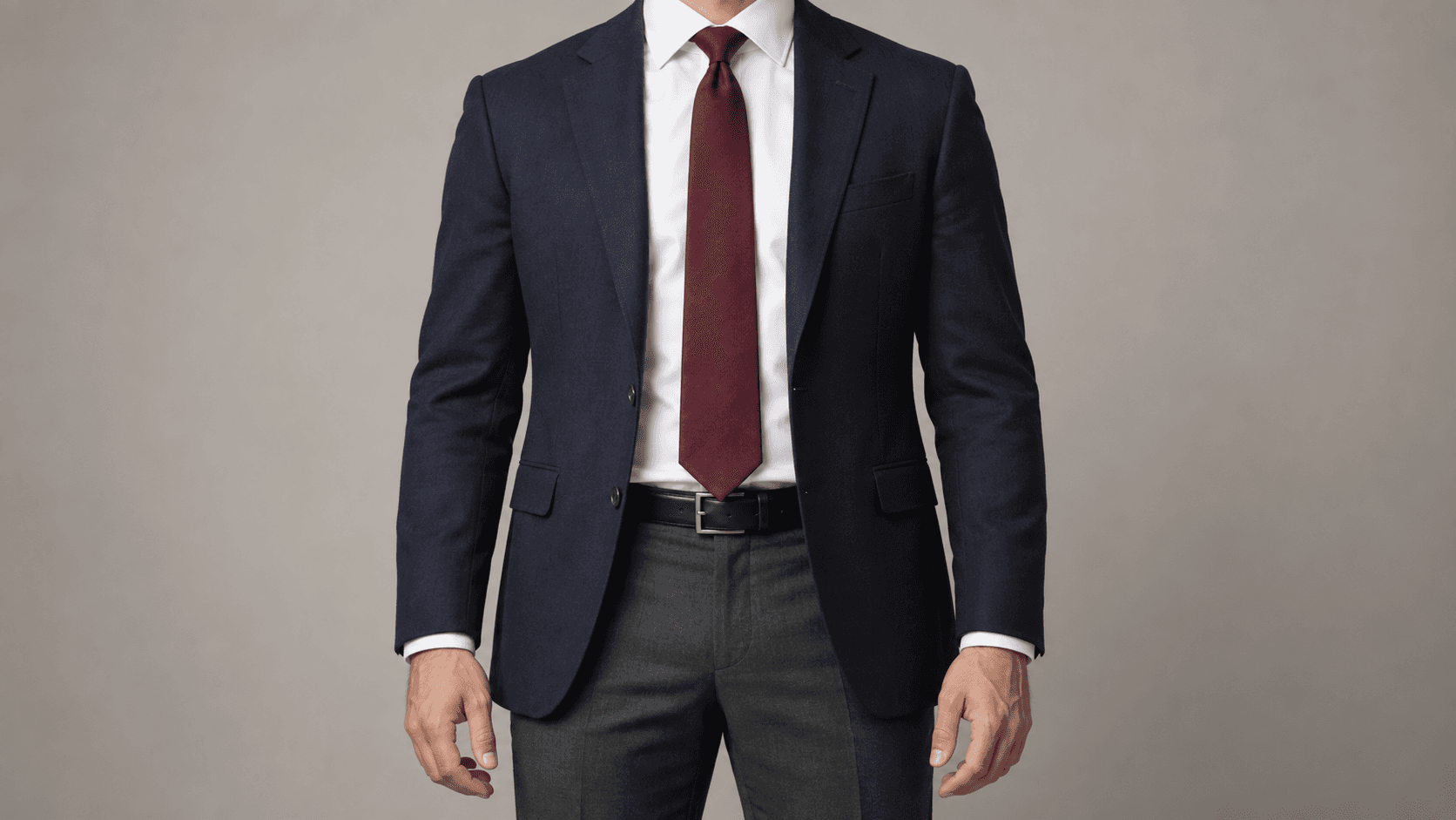 Anonymous model in navy blazer, white shirt and burgundy tie ending at the belt buckle.