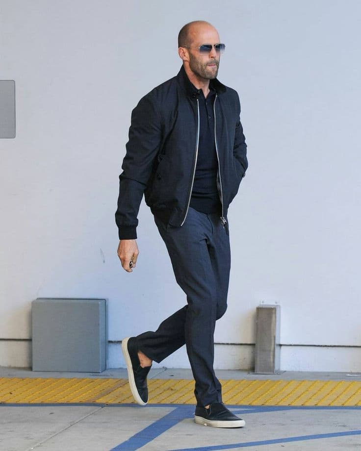 Jason Statham’s Navy Bomber & Slip-On Sneakers Outfit