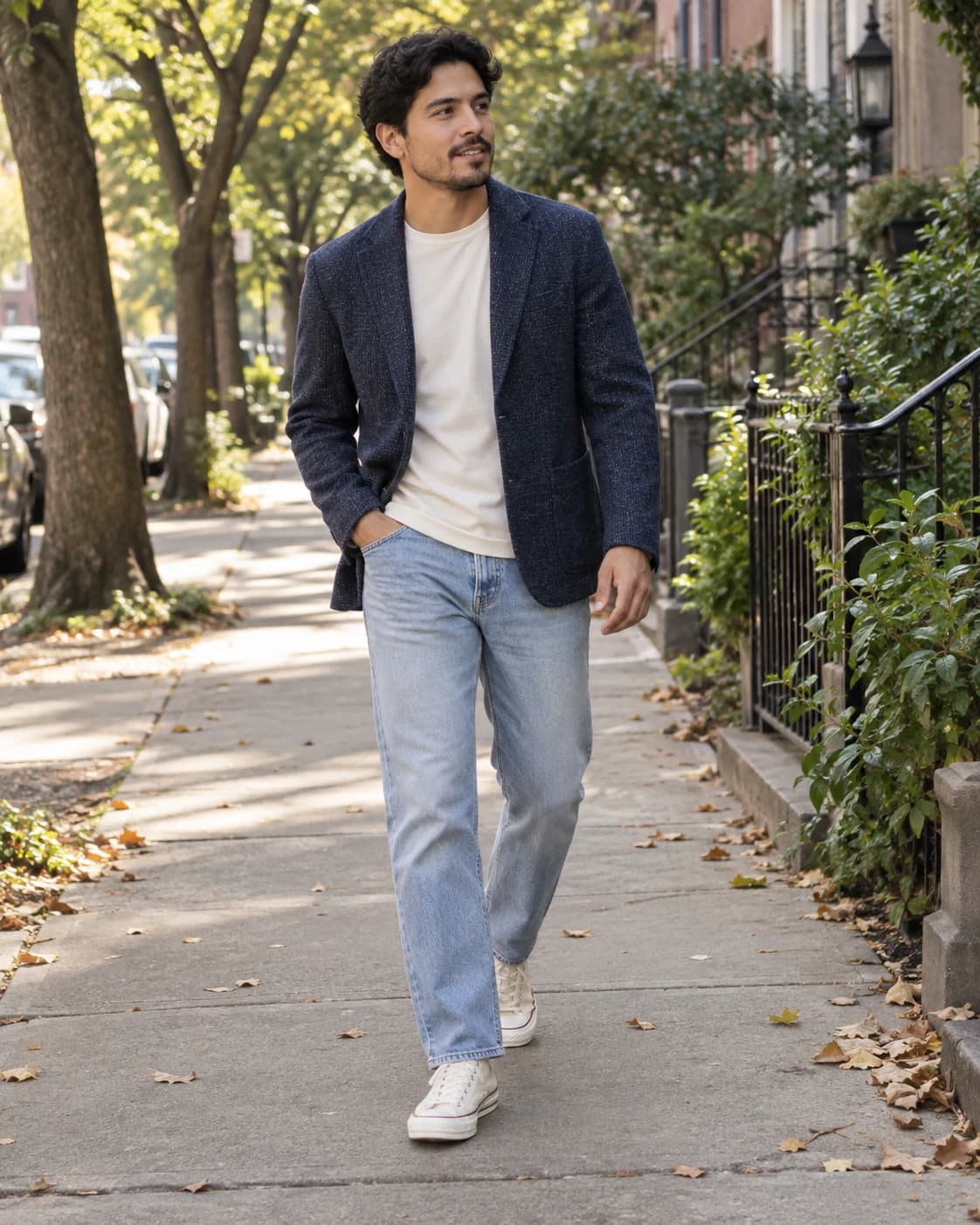 Adult Latino man in a casual navy tweed sport coat, cream tee, light-wash jeans and off-white sneakers