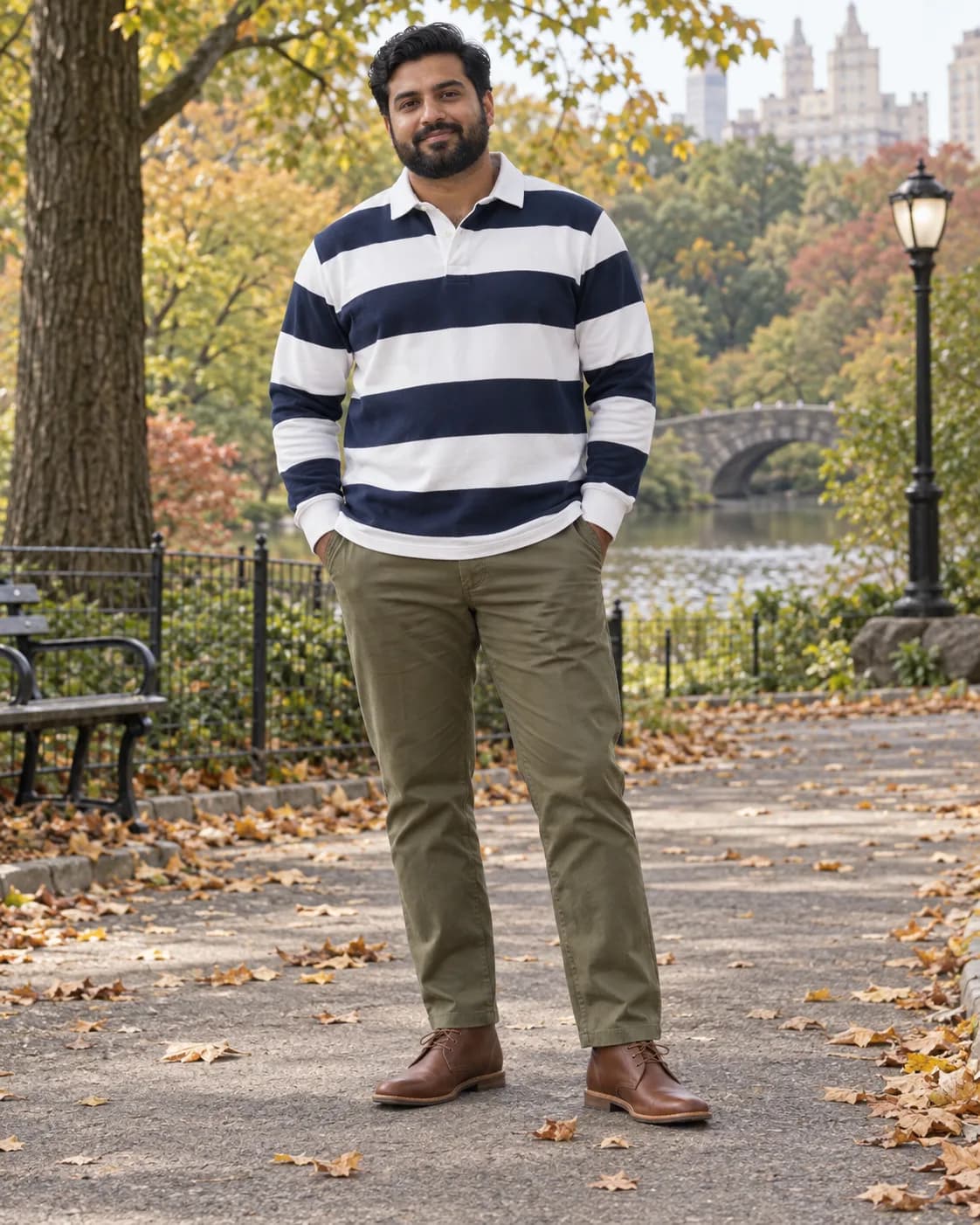 South Asian man in a navy-and-white striped rugby polo with olive chinos and cognac chukka boots