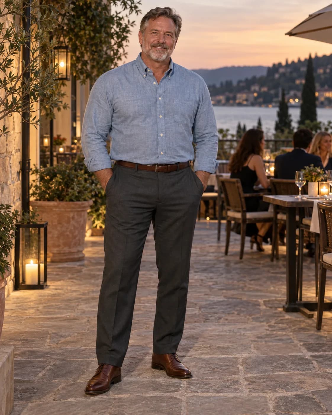 White man in a light-chambray button-down with charcoal trousers and brown dress oxfords outside a restaurant